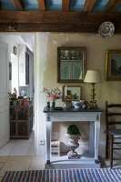 Antique console table below mirror in hallway