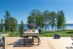 Terrasse mit Seeblick, gedeckter Tisch und Holzdielenboden