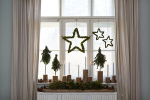 Window decoration with stars, mini fir trees and candles