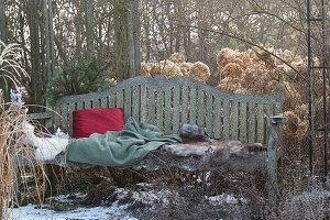 Garden bench with fur, cushions, and Christmas decoration