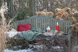 Garden bench with fur, cushions and Christmas decoration