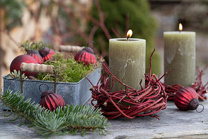 Metalltablett mit Christbaumkugeln und Kerze mit Kränzchen aus rotem Hartriegel (Cornus sanguinea)