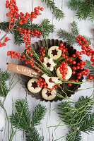 Swiss jam cookies, bird cookies, holly berries, blueberry twigs, and cinnamon stick in old baking tin