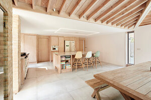 Moderne offene Küche in Naturtönen mit Holzbalkendecke