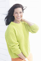 Mature, dark-haired woman in a green and yellow knit sweater