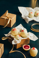 Pralines with raspberry filling, white chocolate coating and red sugar sprinkles