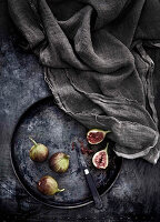 Figs on a vintage metal tray next to a grey cloth