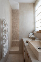 Tiled bathroom with shower stall in beige tones