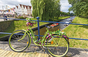 Fahrrad mit Blumenschmuck auf Steinbrücke, Mittelburggraben, Marktplatz, 'Klein Amsterdam des Nordens', Friedrichstadt, Nordfriesland, Schleswig-Holstein, Deutschland