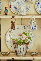 Teller und Teetasse mit Zimmerpflanze auf Küchenkommode
