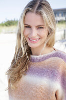 Young blond woman in a knitted jumper with a colour gradient