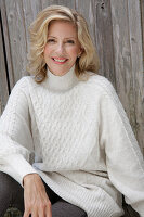 Mature blonde woman in white knitted jumper and grey leggings