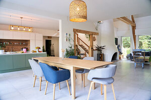 Dining table with upholstered armchairs in open plan living area