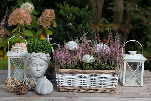 Autumn decoration with bust, basket with mushroom figures, lanterns, and heather (Erica)