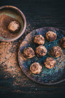 Chocolate almond truffles coated in cacao powder on a ceramic plate