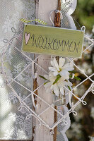 Magnolia branch (Magnolia stellata) and welcome sign on the window