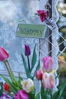 Welcome sign and tulip bouquet as decoration at the window