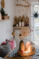Christmas decoration with dried flower heads, lantern and candle on tray