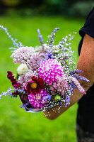 A hand holding a late summer bouquet