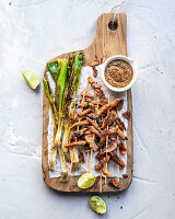 Grilled chicken skewers with spring onions and limes