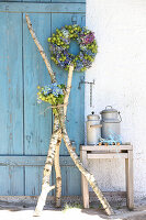 Wreath and bouquet of hydrangeas and love-in-a-mist in the green arranged with birch branches