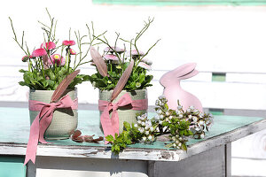 Bouquet of bellis with Easter decoration in green containers