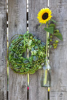 Bouquet of sunflowers and poppy capsules in milk cans