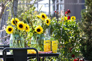 Strauß aus Sonnenblumen und Mohnkapseln in Milchkannen