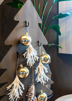 Wooden Christmas tree with hooks, gold-coloured baubles and white decorative elements