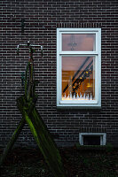 Window decorated for Christmas with illuminated staircase in the background