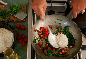 Reisgericht mit Tomaten und Spinat im Wok zubereiten
