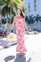 Brunette woman in long red and white printed summer dress