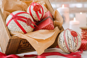 Ornate DIY Christmas ornament with book pages, wax seal, and red fabric ribbon