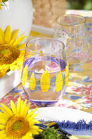 Glasdeko mit einzelnen Sonnenblumen-Blütenblättern