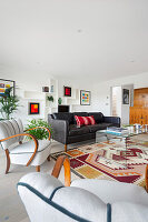 Mid-Century seating and colorful artwork on white wall in a bright living room