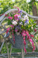 Blumenstrauß in alter Gießkanne, Tränendes Herz (Dicentra Spectabilis) und Akelei (Aquilegia) an Gartentür hängend