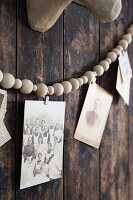 DIY garland of wooden balls with vintage photos on wooden wall