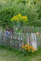 Blumenbeet im Garten mit Staketenzaun