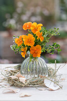 Garden pansy (Viola wittrockiana) with thyme in vase, egg shells and Easter wreath