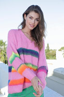 Young woman wearing a pink knitted jumper with colorful stripes