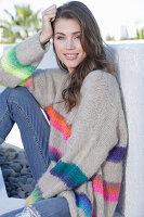 Young woman wearing a grey knitted jumper with colorful stripes