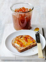 Jam spread on wholemeal toast, jam jar in the background