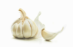 Garlic bulb and a clove of garlic against a white background