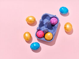 Top view layout with colored easter eggs on pink background