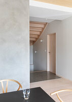 View into the staircase with wooden stairs, with a dining table in the foreground