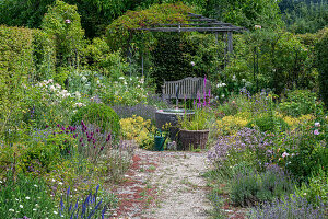 Water fountain and seat with wooden bench in summer garden