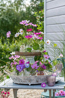 Flower etagere with jewellery basket, gladioli and showy bindweed