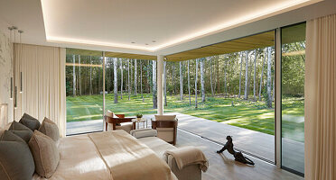 Bedroom with generous glazing and view of the forest