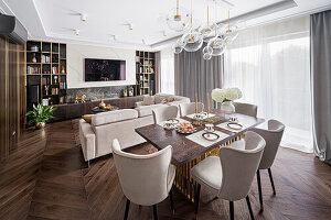 Hampton style open plan living room, dark brown color palette with gold accessories, cool beige sofa, and chair upholstery
