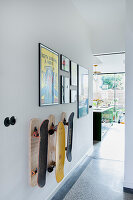 Wall with skateboards and framed pictures in modern hallway